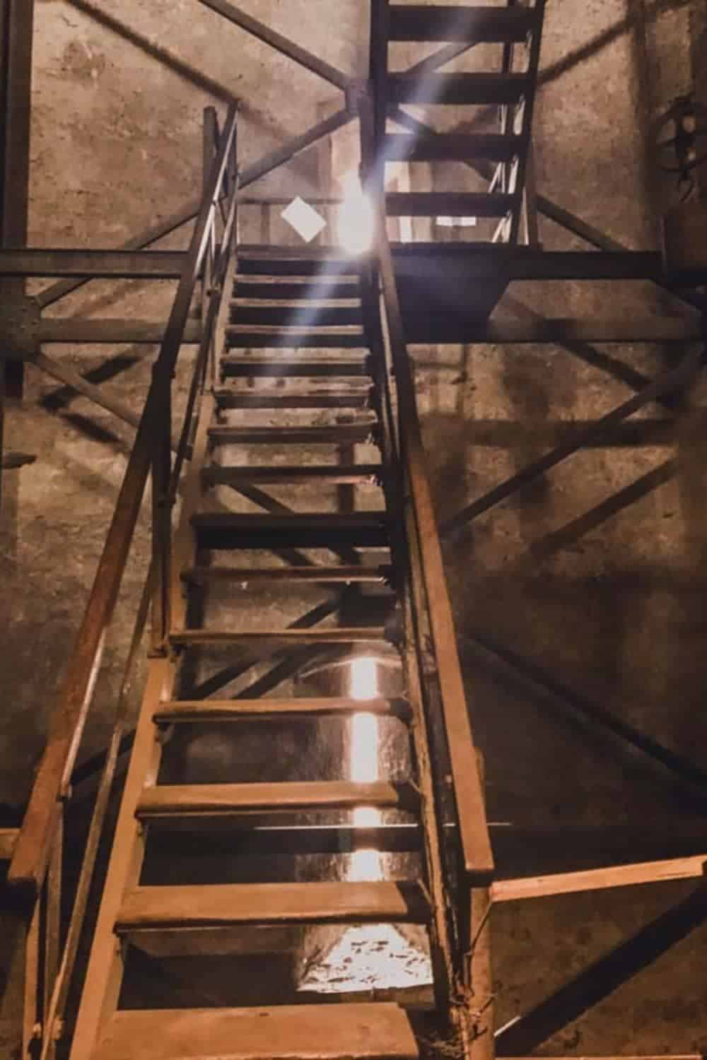 Rustic wooden staircase leading to the belfry of Sibiu's Lutheran Cathedral, a journey into the city's historic depths that underscores why Sibiu is worth visiting