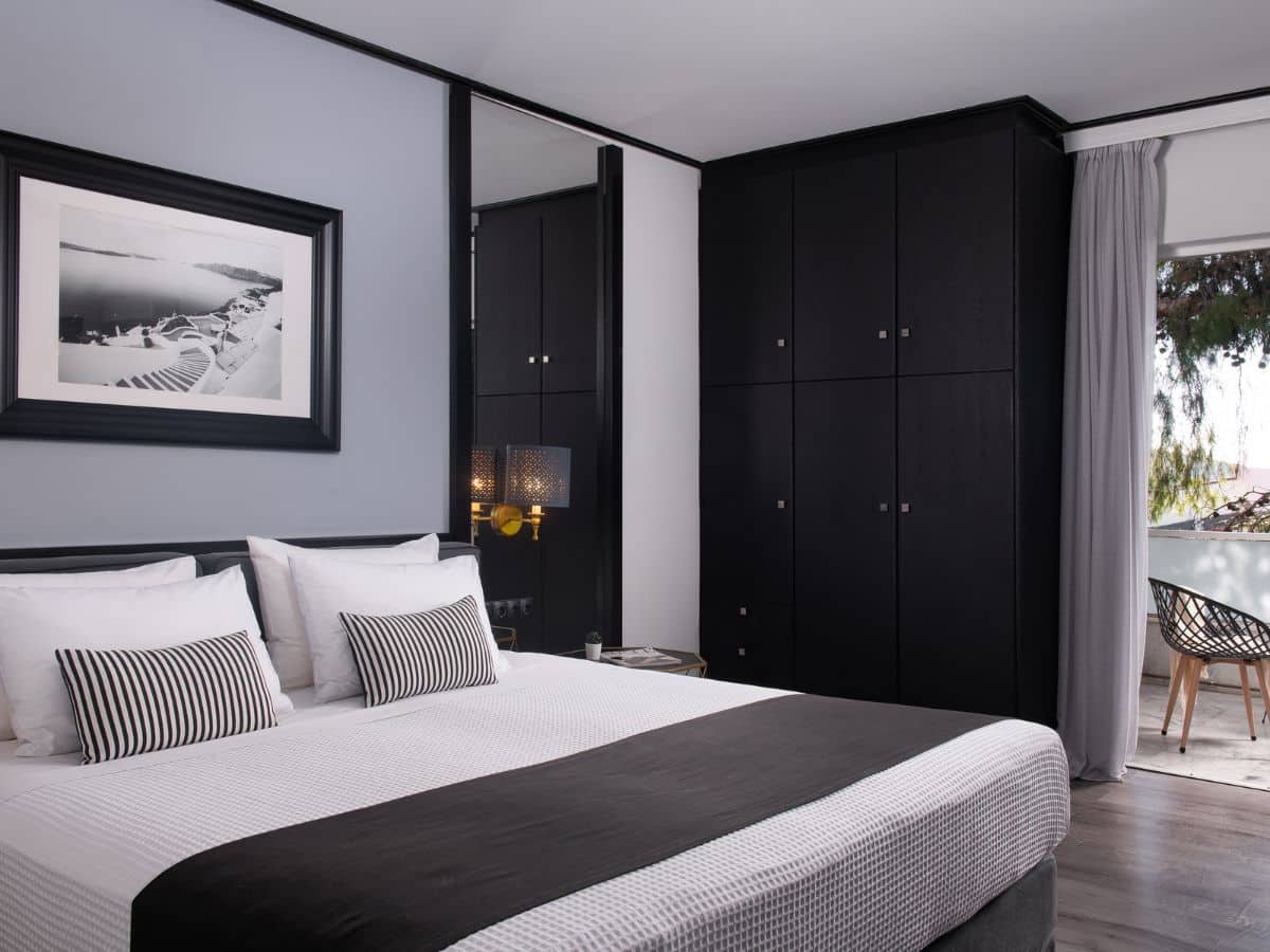 Modern hotel room with black and white decor.