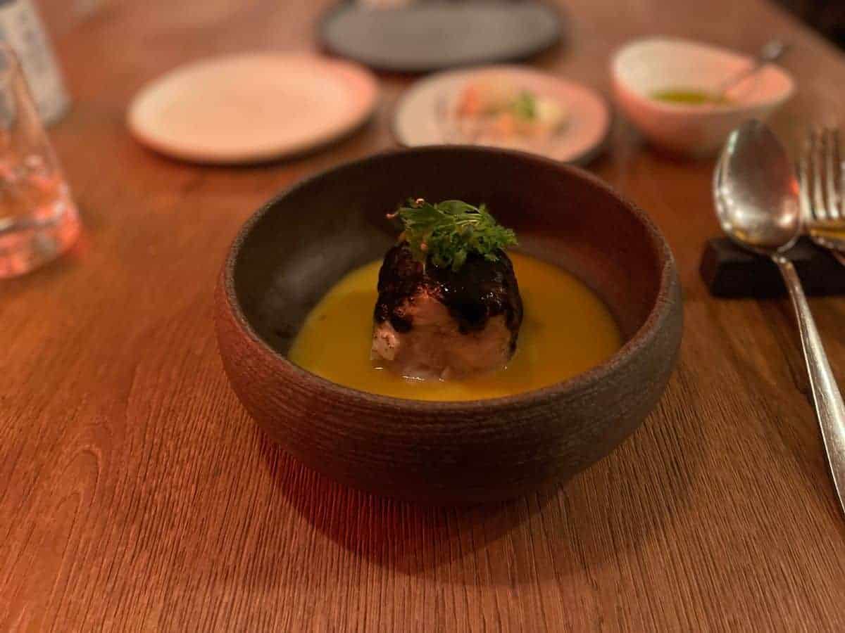 a bowl fill with broth and fish at Simul a must visit restaurant in Athens