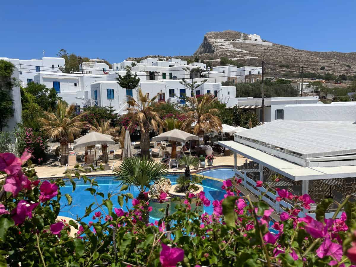 view of the pool, pink flowers and nearby hotels from the balcony of hotel polikandia. A less expensive choice than Mykonos