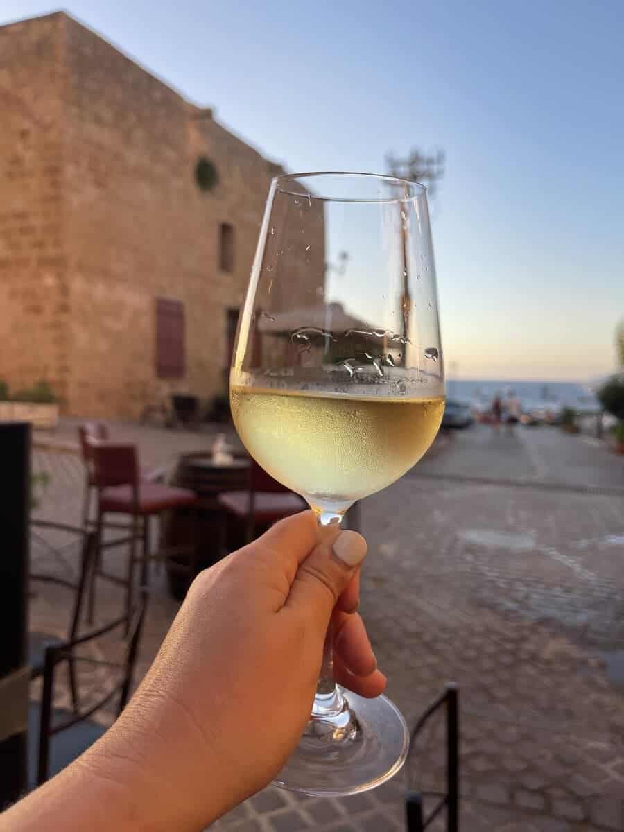 Glass of wine in hand in Greece