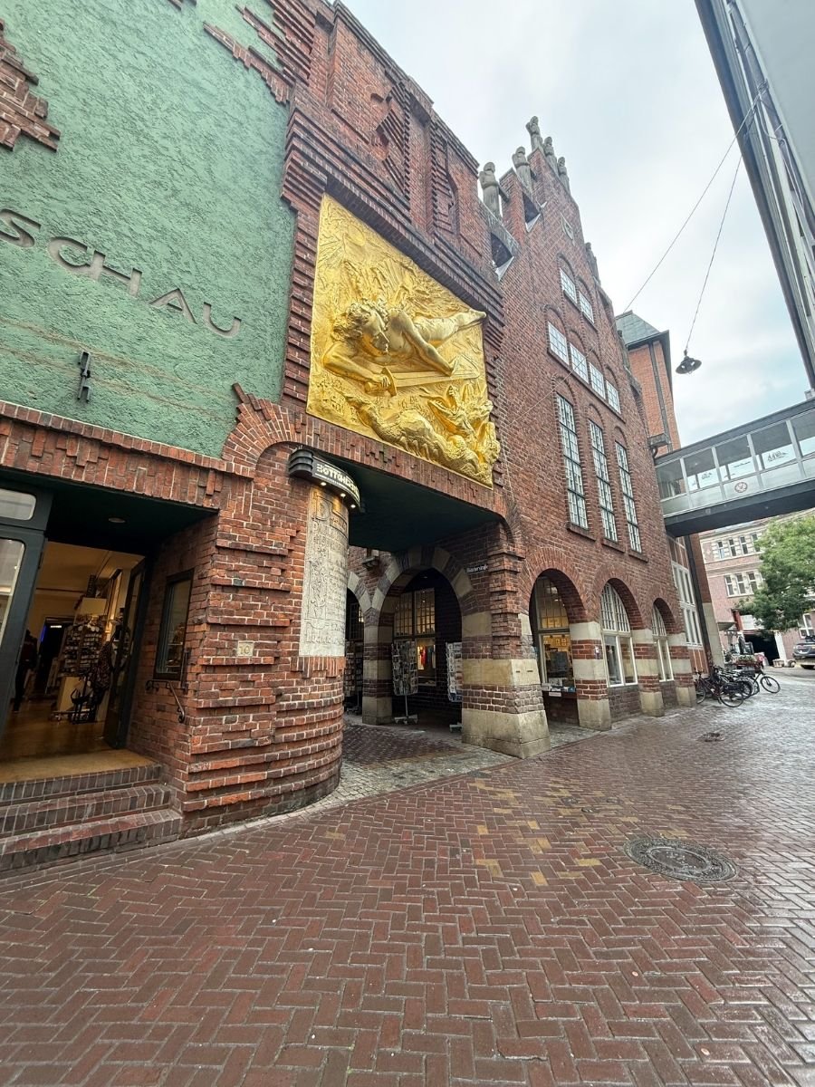 Golden relief artwork displayed on a brick building along Böttcherstraße in Bremen.
