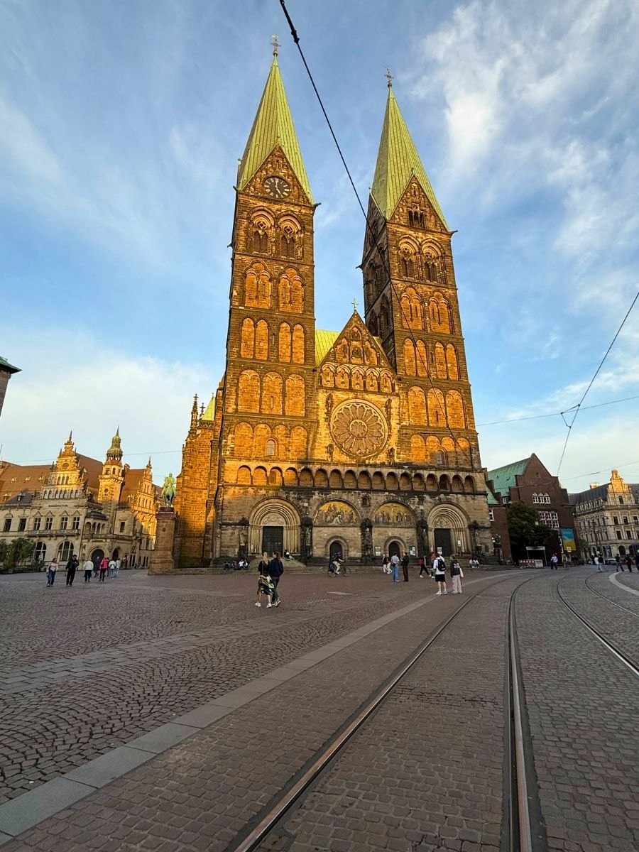 A wide-angle view of Bremen’s St. Peter’s Cathedral, highlighting its Gothic façade, rose window, and twin towers.
