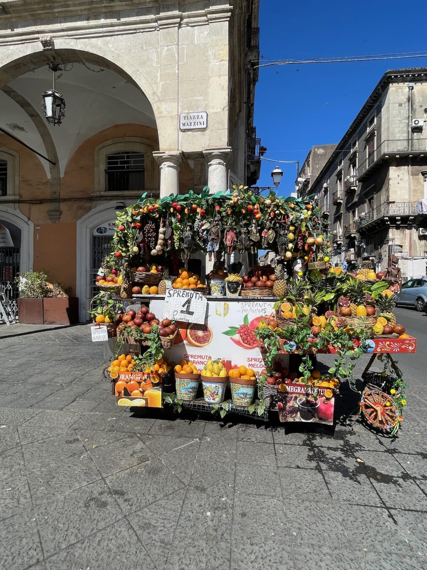 A colorful fruit and juice stand in Piazza Mazzini, Catania.