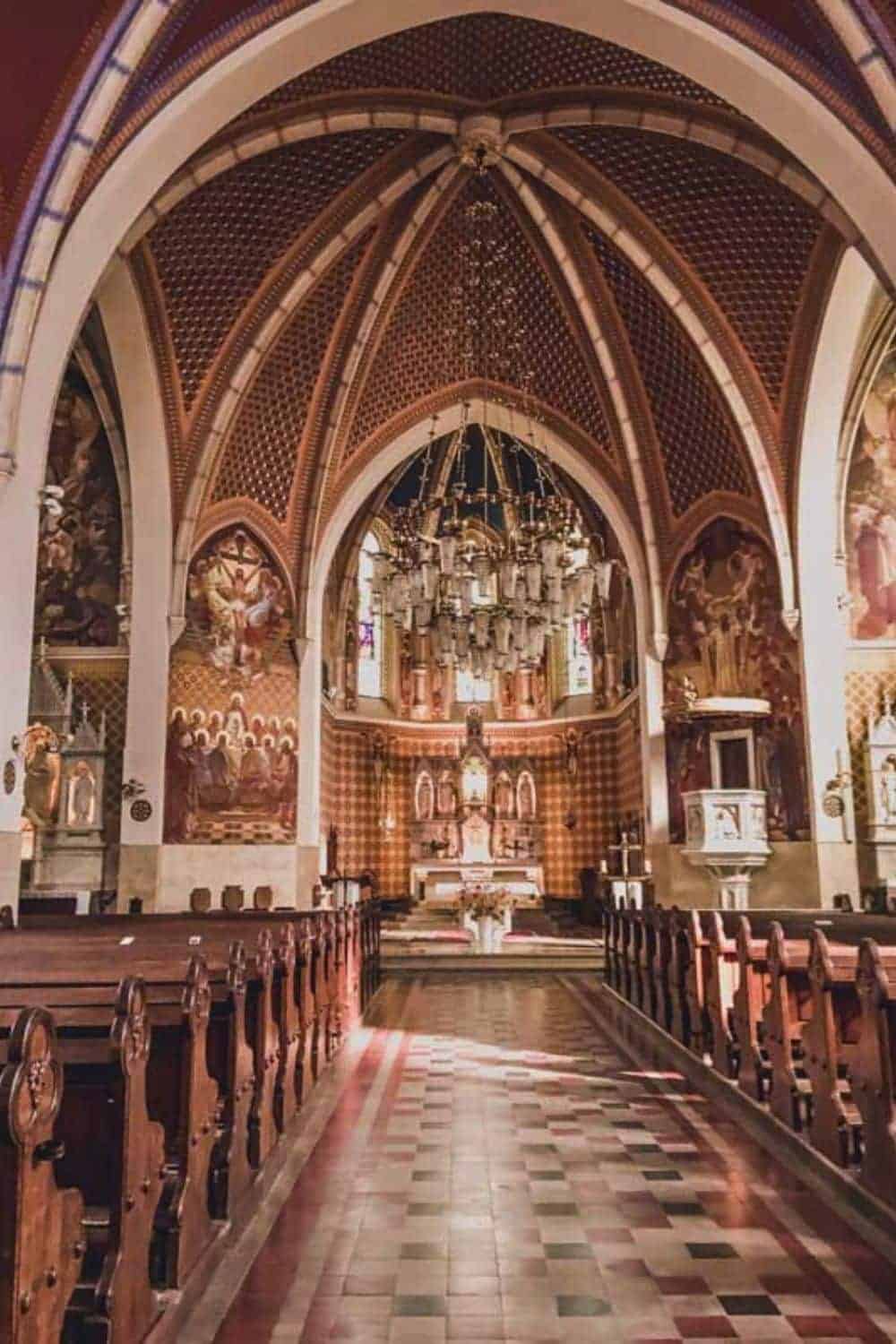 The ornate interior of a church with vibrant frescoes and Gothic architecture, suggesting a cultural visit inside Lake Bled's historical sites during the winter season