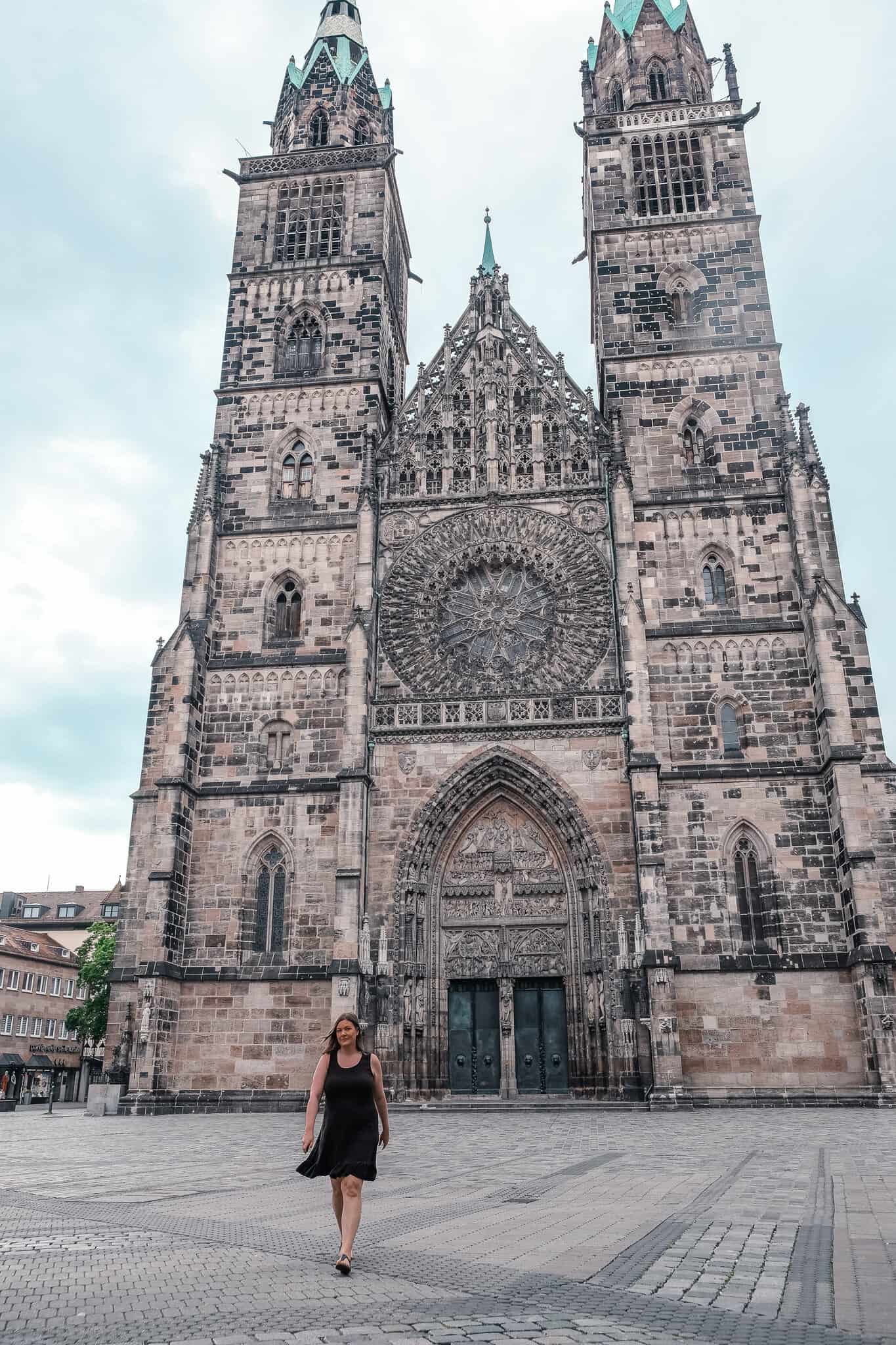 A solo woman walking in front of the Cathedral in Nuremburg