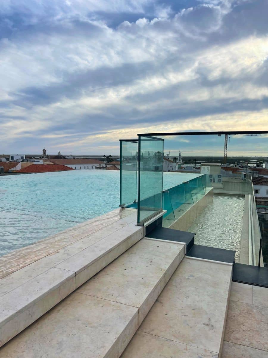 Rooftop infinity pool with panoramic views of Faro’s old town and the coast.