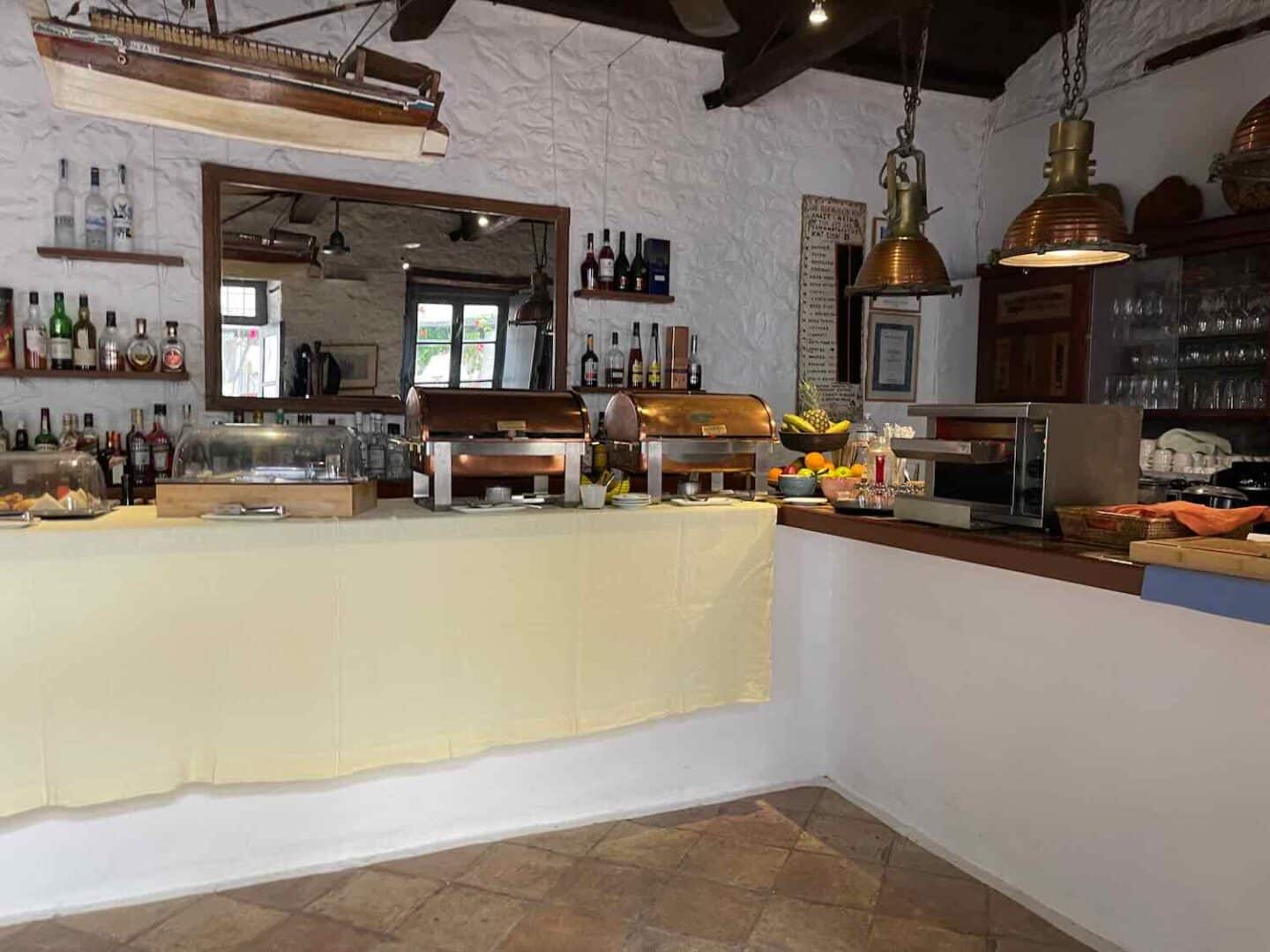 A spread of Greek breakfast items laid out on a table at a hotel in Hydra, featuring fresh bread, local jams, and assorted pastries, inviting guests to savor traditional flavors.