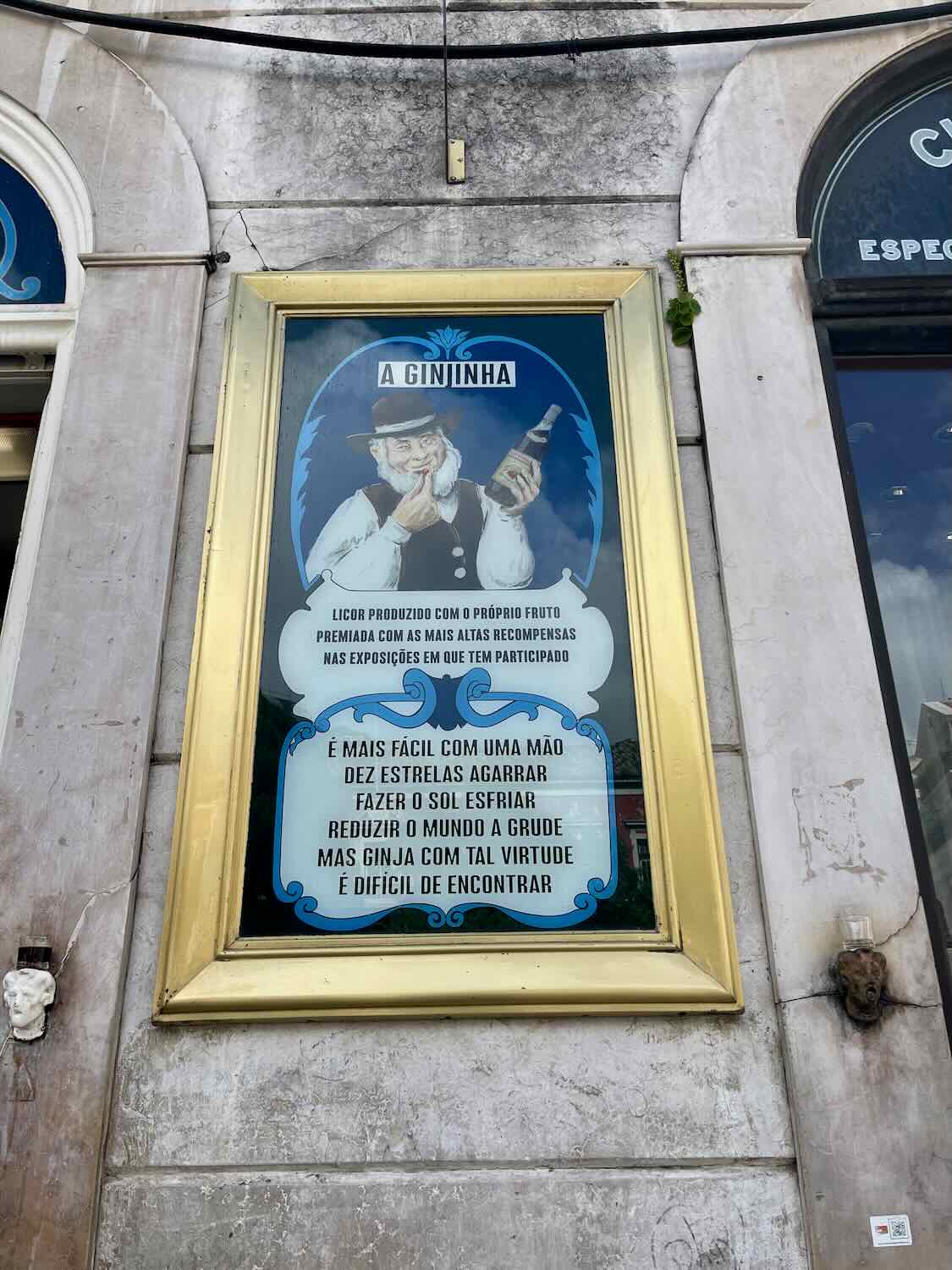 Close-up of the iconic 'A Ginjinha' sign and a colorful poster, inviting visitors to taste the traditional Lisbon ginjinha liqueur, a staple of Portuguese culture.