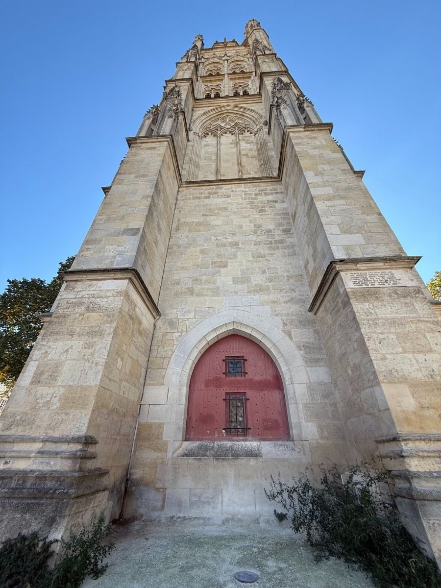 Ground-level upward shot of Tour Pey-Berland, Bordeaux, highlighting its towering Gothic architecture and stonework.