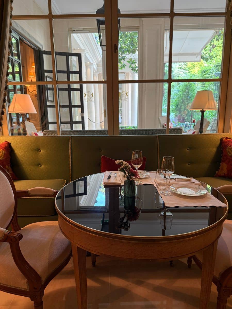 Chic indoor dining area with elegant chairs, glass table, and large windows overlooking the terrace.