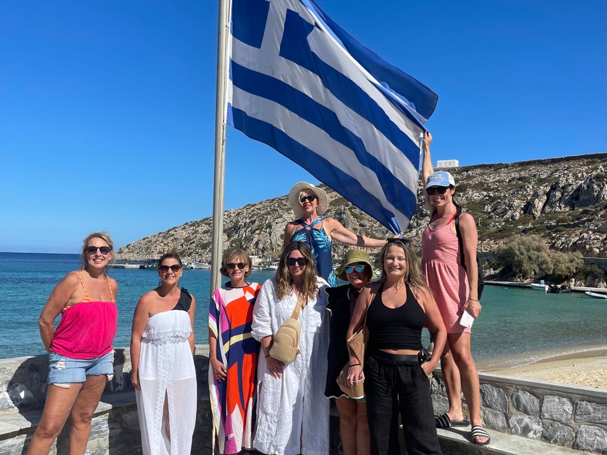 Women standing under a Greek Flag in Naxos.