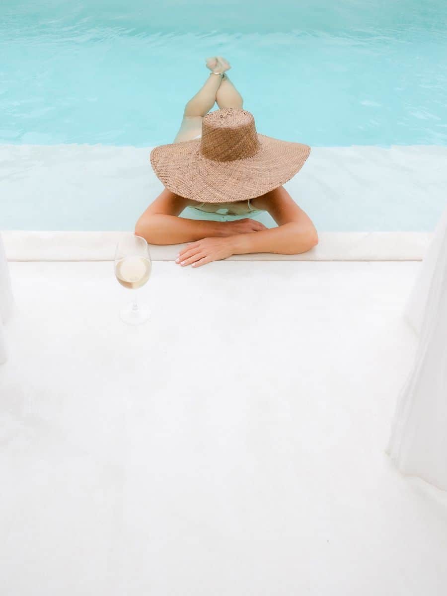 woman in a pool with a hat on. 