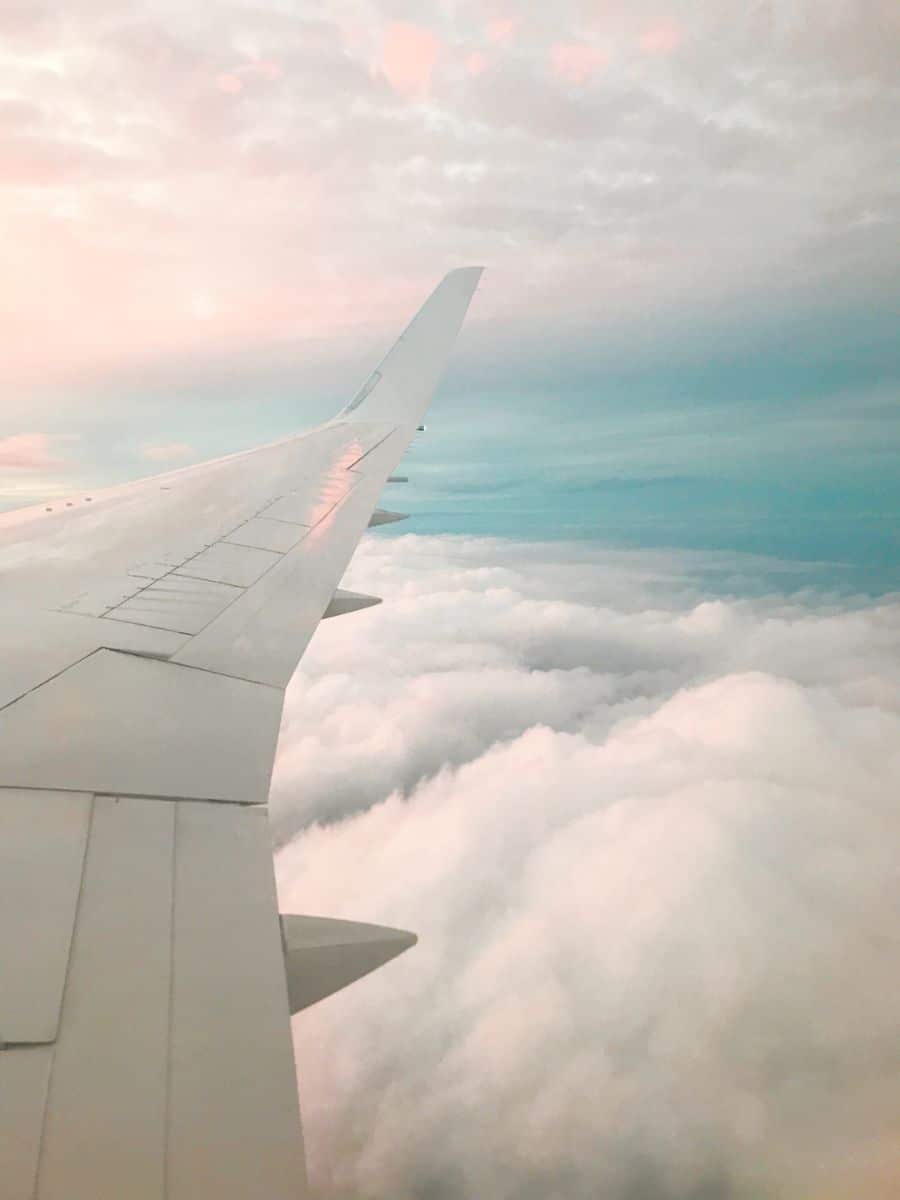Airplane wing over puffy clouds.