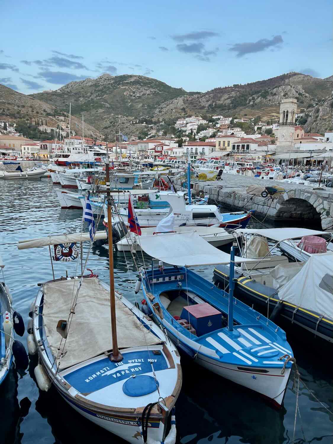 Small colorful boats in the ocean on the Greek island of Hydra.