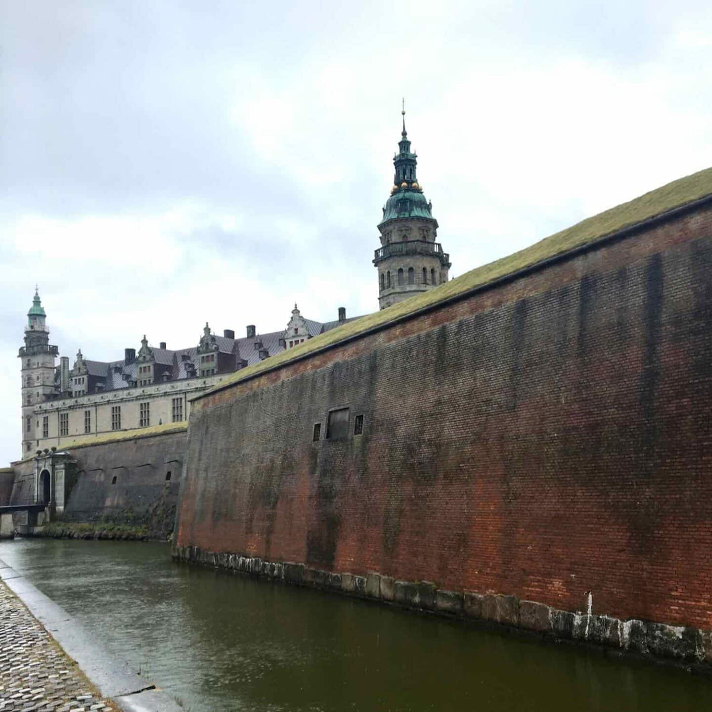 Panoramic view of Kronborg Castle and its surroundings, including the waterfront and distant cityscape.