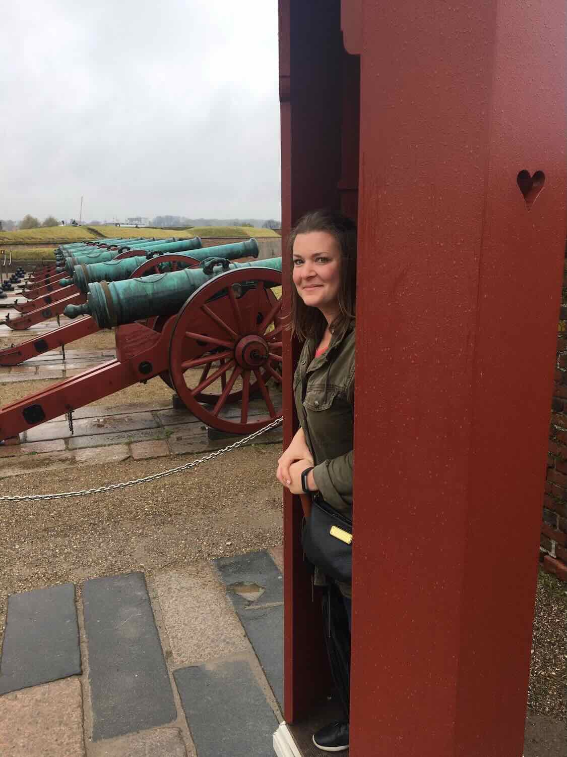 a woman standing in front of cannons at Kronborg castle.