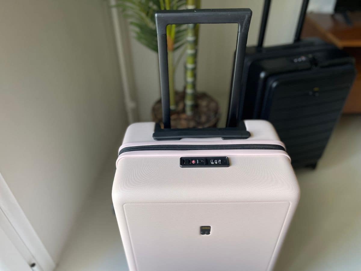 The top of a pink suitcase that shows the TSA locks