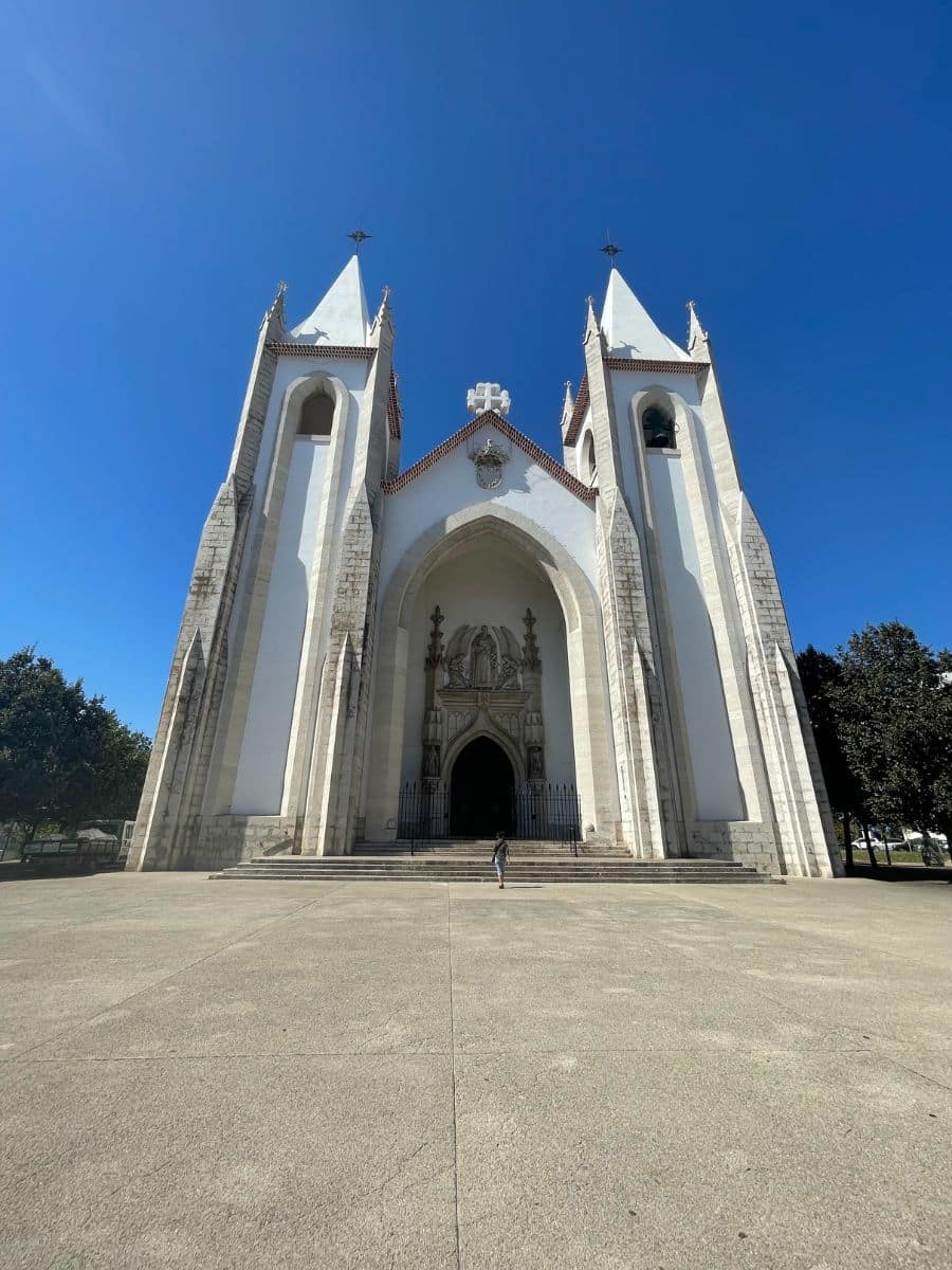 Tall, pointed white church under a clear blue sky.