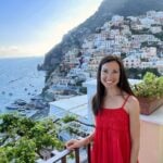 A girl in front of a cliffside village in Italy