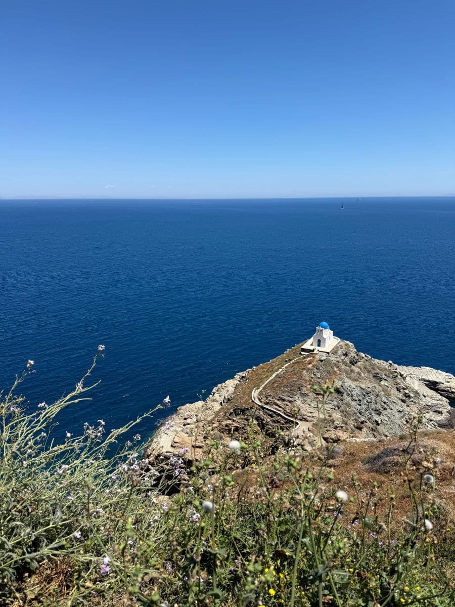 Scenic view of a whitewashed chapel with a blue dome overlooking the Aegean Sea in Greece