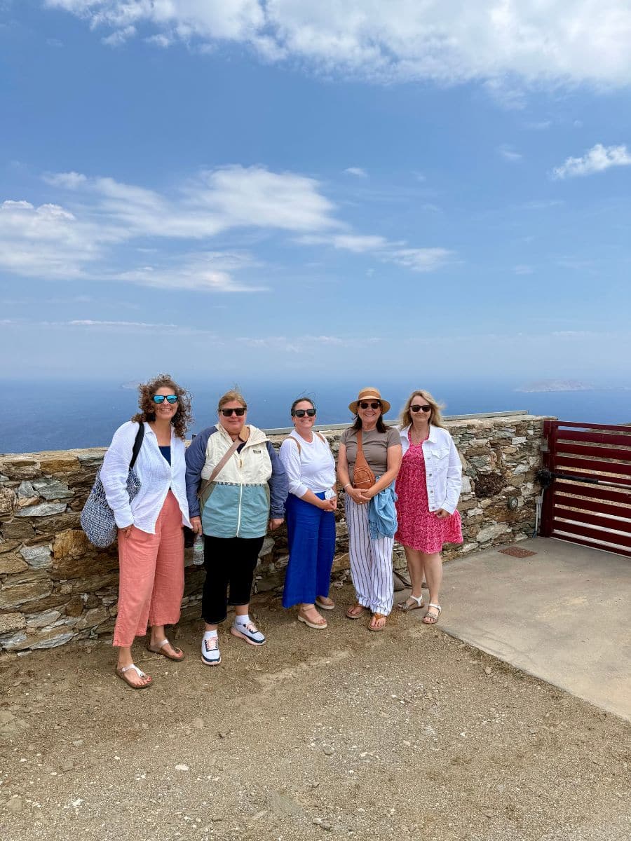 Small group of women posing together at a scenic lookout on a Greek island tour for women