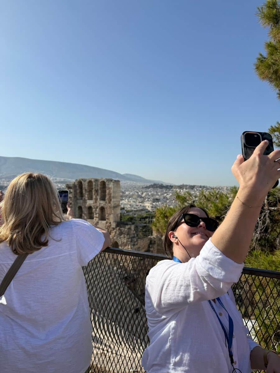 Women taking selfies at the Acropolis with Athens city views on a guided women-only tour of Greece
