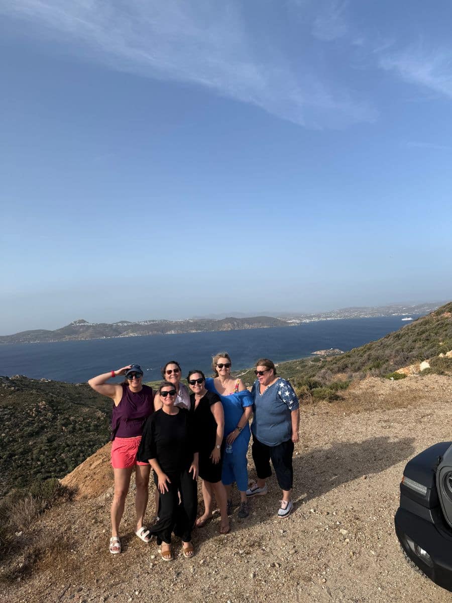 Group of women posing with Aegean Sea views on a women-only Greek island adventure