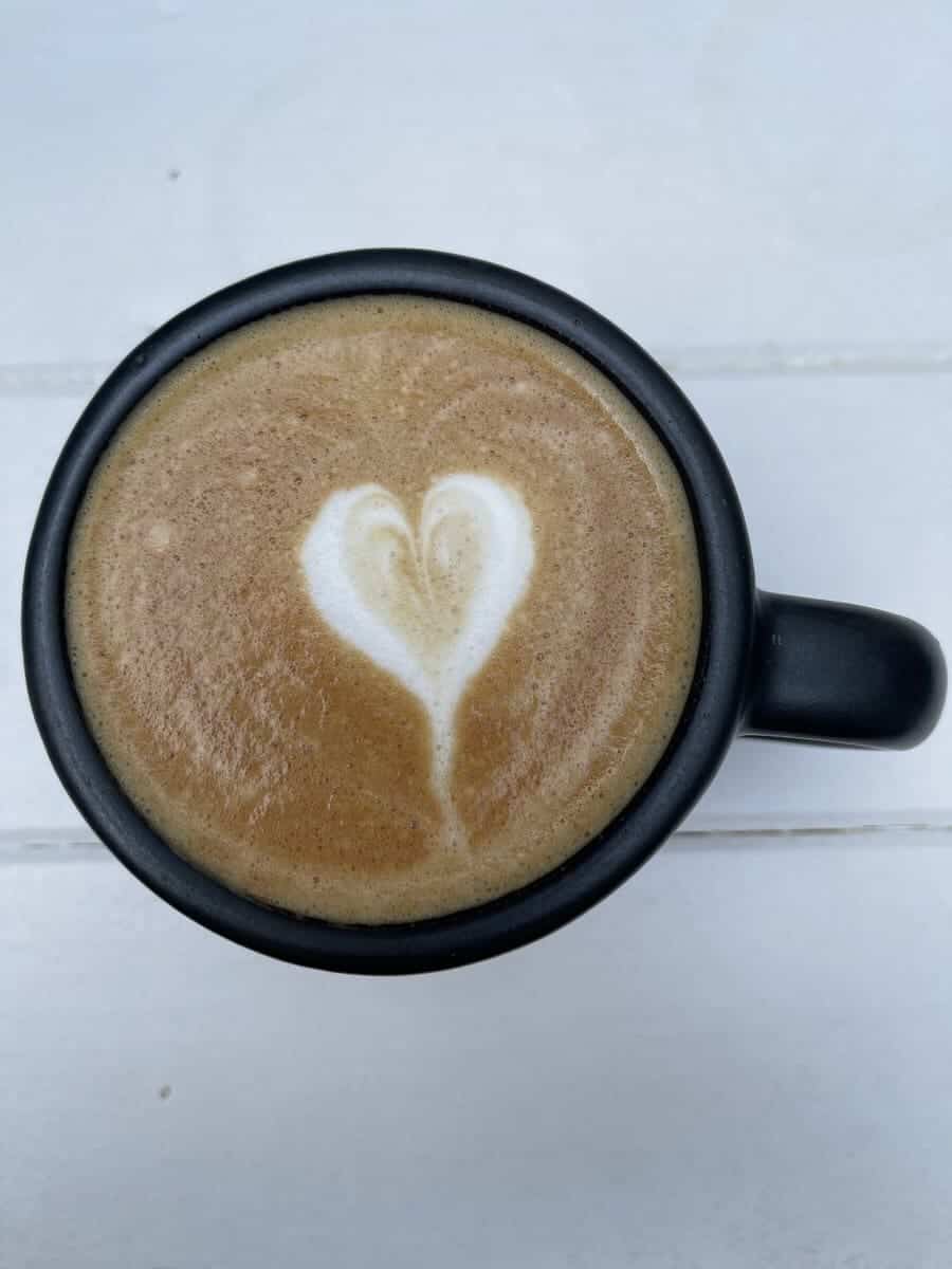 Coffee in a black mug on a white table
