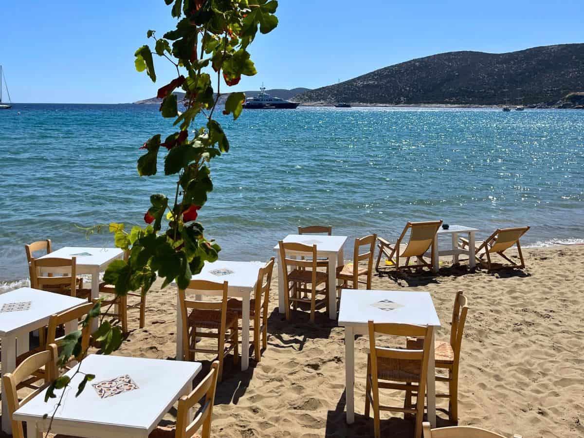 A bunch of tables sitting in the sand seaside in Sifnos
