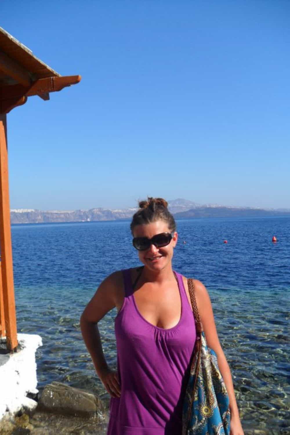 a woman standing by the ocean by herself. 