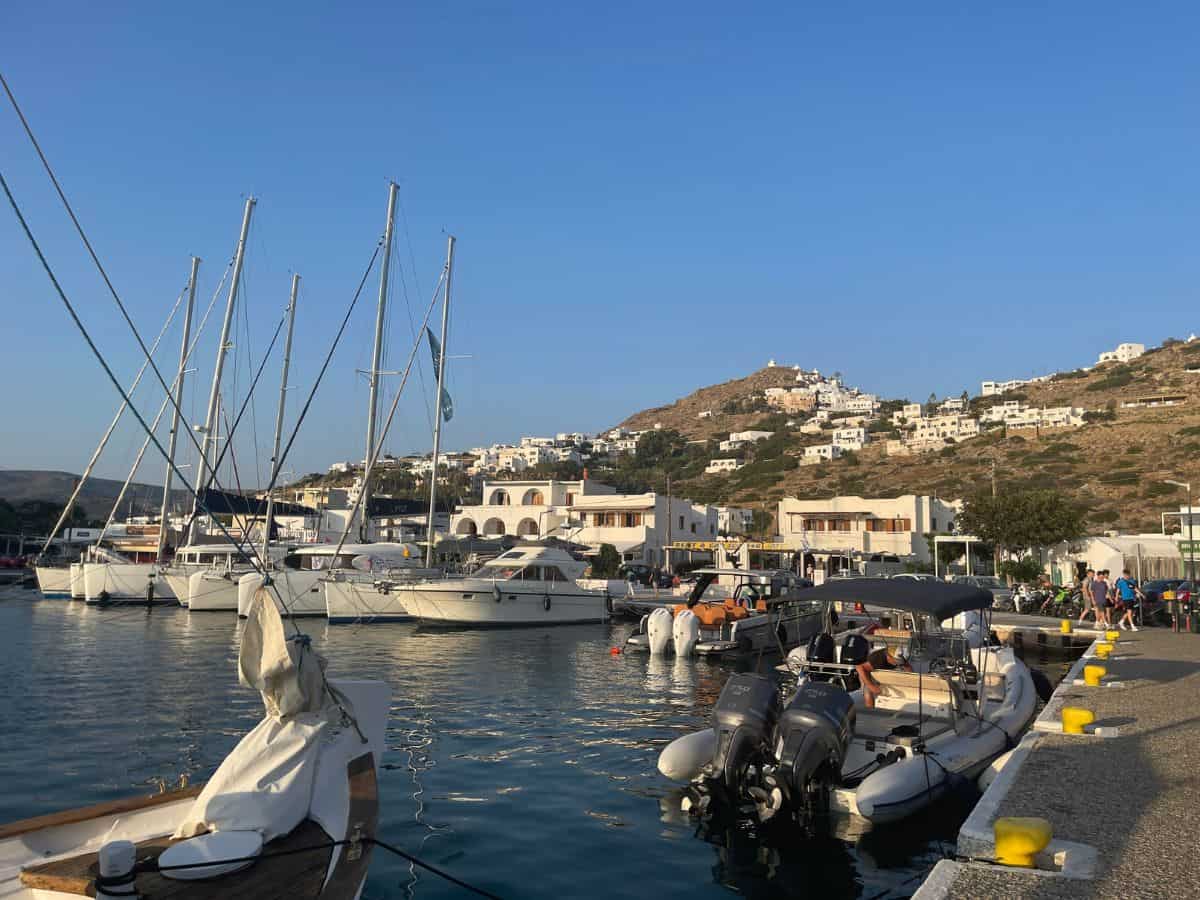 how to manifest travel to an island. Picture of boats in the water in the harbor on the Greek Island of Ios. 