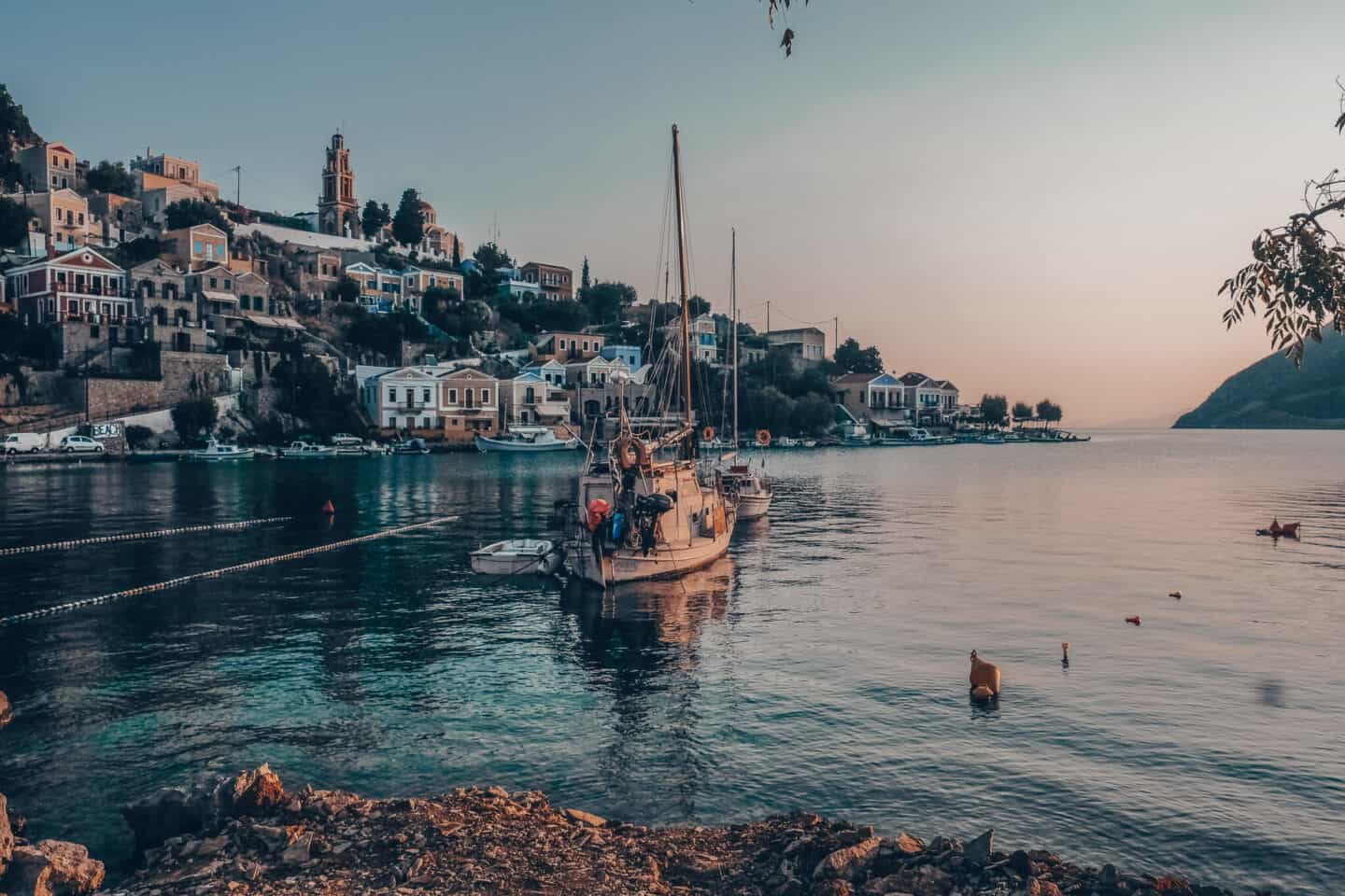 Sailboats in the harbor at sunset in Symi, Greece, one of the stops on my Rhodes itinerary for solo females.