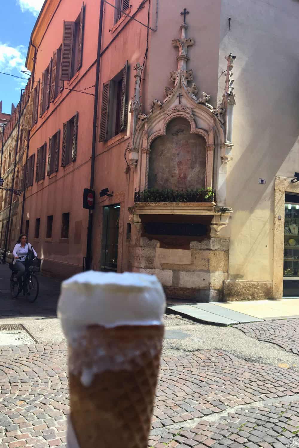an ice cream cone half eaten on the streets of Verona italy. 