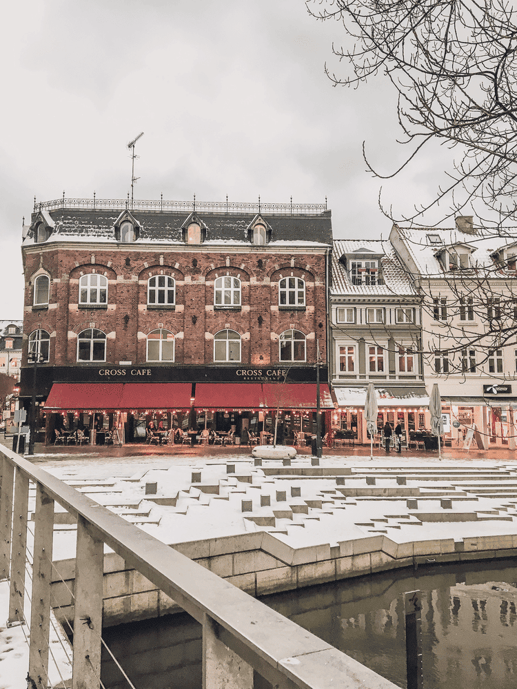 Perfect Copenhagen to Aarhus Itinerary, a snowy plaza and cafe in the city.