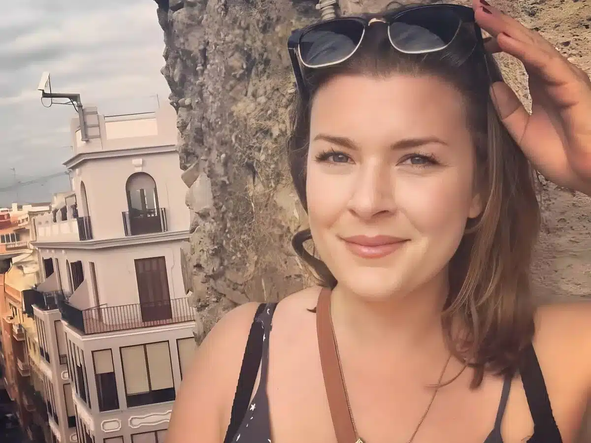 A solo woman traveling in Spain. The city of Valencia behind her